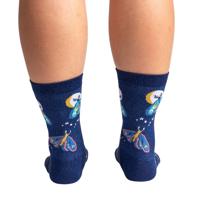 A pair of blue socks with a pattern of moths and crescent moons.