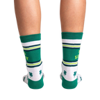 Rear view of the socks on a person's legs.  Shows the back design of the socks against a black background.
