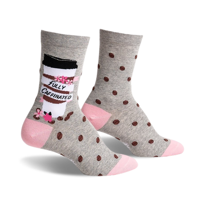 gray coffee bean patterned socks with pink toe and heel. left sock has cartoon coffee cup design with the words "fully caffeinated printed on it. womens. crew length.   