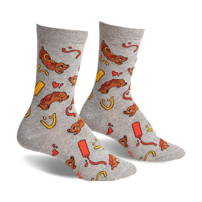 a pair of grey socks with a pattern of hot dogs, ketchup, mustard, and smiley faces. the socks are viewed from the side.