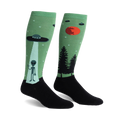Pair of green and black knee-high socks featuring an alien, UFO, and forest scene.  