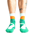 Lifestyle shot of a person's legs wearing the teal and light blue mountain slipper socks.