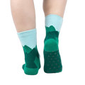 Back view of a person's legs wearing the teal and light blue mountain slipper socks, showcasing the non-slip soles.