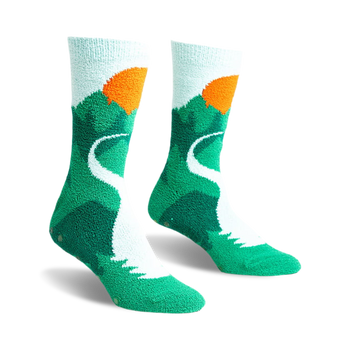 a front view of a pair of socks with a mountain, winding road, and sunset design. the socks are green with a white road and an orange sun.