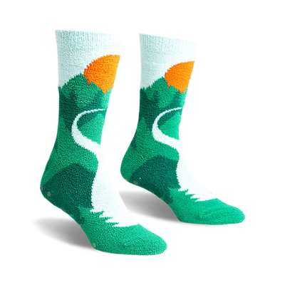 a front view of a pair of socks with a mountain, winding road, and sunset design. the socks are green with a white road and an orange sun.