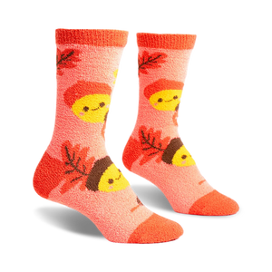 front view of a pair of fuzzy pink socks with brown acorns and yellow smiling faces.