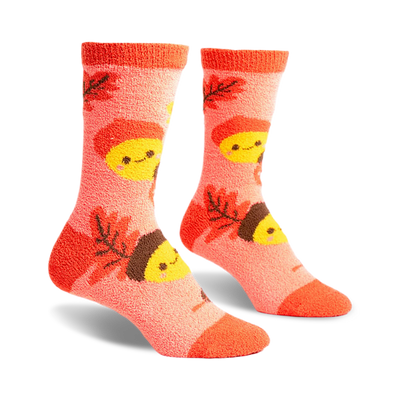 front view of a pair of fuzzy pink socks with brown acorns and yellow smiling faces.