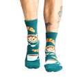 Lifestyle shot of model wearing teal blue coffee and croissant slipper socks.