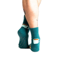 Back view of model wearing teal blue coffee and croissant slipper socks.
