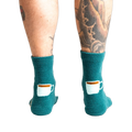 Close-up shot of the back of the teal blue coffee and croissant slipper socks.