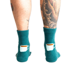 Close-up shot of the back of the teal blue coffee and croissant slipper socks.