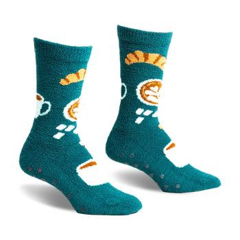 pair of teal fuzzy socks with a coffee cup and pastry design. the socks have black grippers on the bottom.  the socks are laying flat on a white background.  they are viewed from the front.