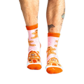 Lifestyle shot of a person wearing the pink gingerbread slipper socks.