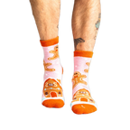 Lifestyle shot of a person wearing the pink gingerbread slipper socks.
