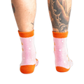 Back view of model wearing the pink and orange gingerbread socks.