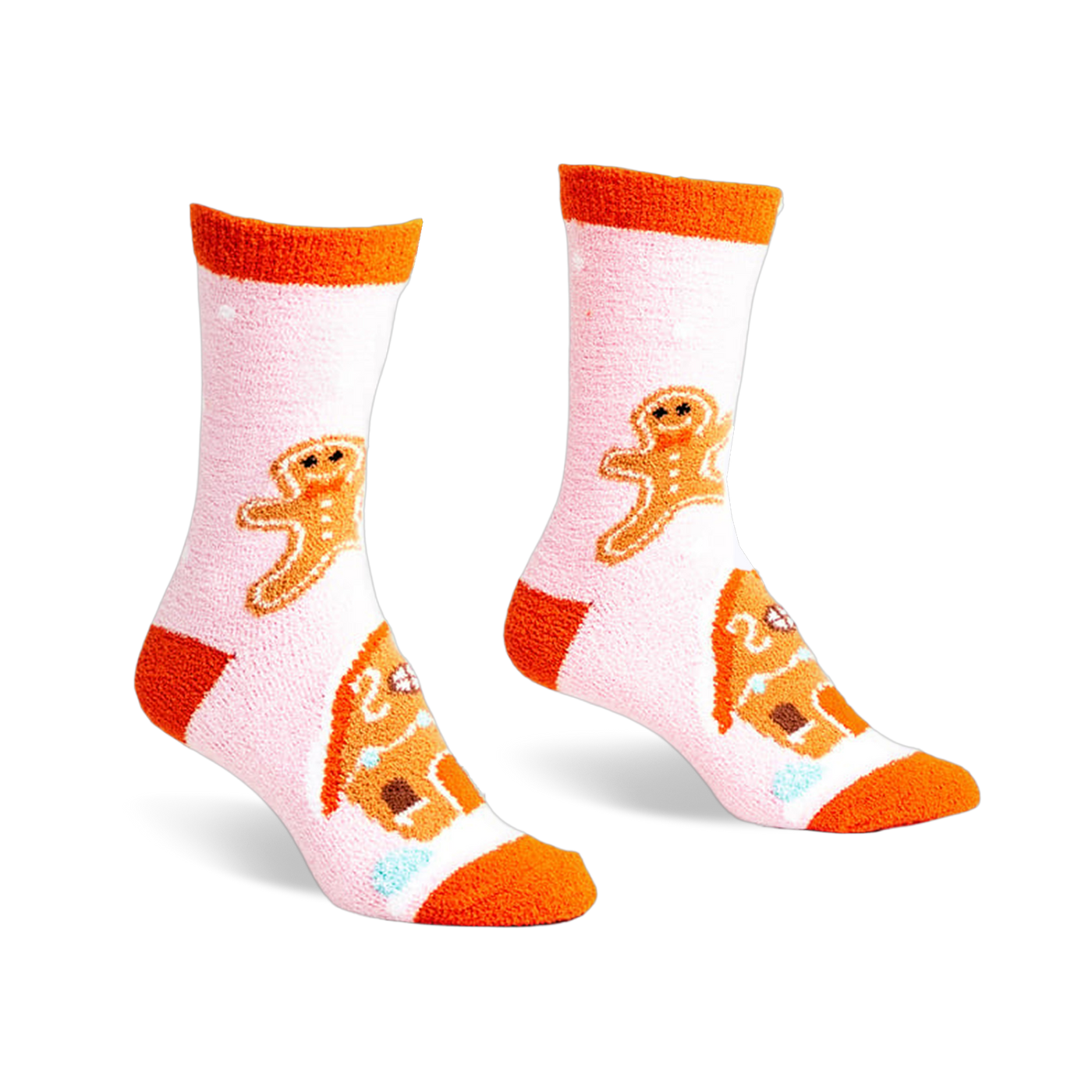Pair of pink fuzzy slipper socks with orange cuffs. Gingerbread men and houses are embroidered on the socks.