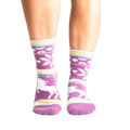 Lifestyle shot: Woman's legs wearing purple unicorn slipper socks.