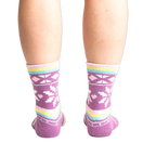 Rear view of socks on legs showing off the pastel stripes and snowflake design.