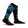Pair of black knee-high socks with teal dragons and orange flames. Fun and vibrant design.