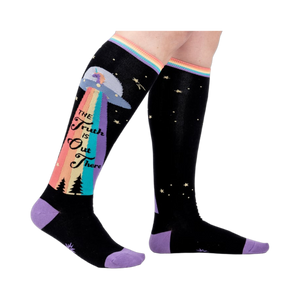 Person wearing a pair of 'The Truth Is Out There' knee-high socks. Shows how they look on.