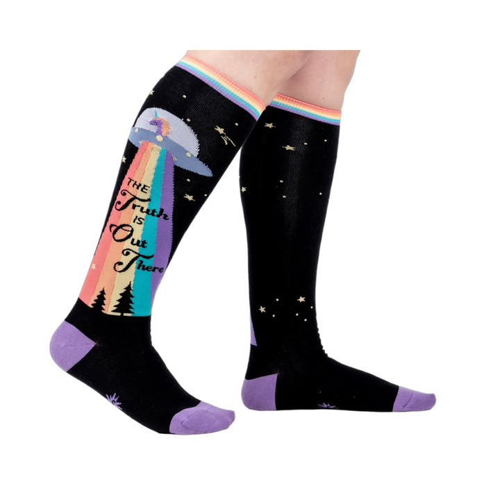 Person wearing a pair of 'The Truth Is Out There' knee-high socks. Shows how they look on.