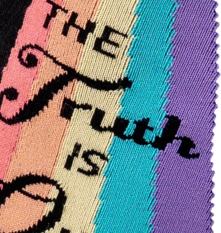 Close-up detail of the 'The Truth Is Out There' text and rainbow graphic on the socks.