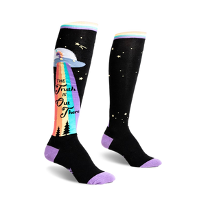 front view of a pair of knee high socks.  the socks have a black background with a colorful rainbow, stars, and a flying saucer.  the text 