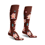 Pair of brown knee-high socks with a whimsical pattern of gingerbread houses, candy canes, and small pine trees.