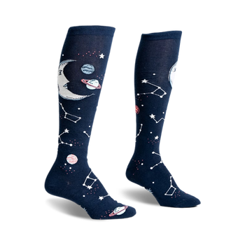 front view of a pair of knee-high socks with a moon, stars, and planets printed on them.