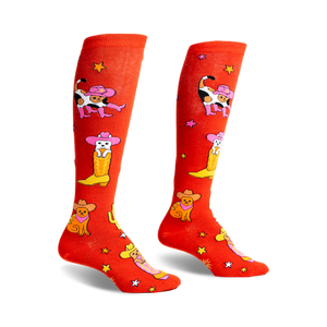 pair of red knee high socks with a white cat wearing a cowboy hat and boots pattern. the socks are shown from a side angle.