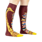 Knee-high socks on a model's legs, showcasing the giraffe and book design.
