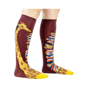 Knee-high socks on a model's legs, showcasing the giraffe and book design.