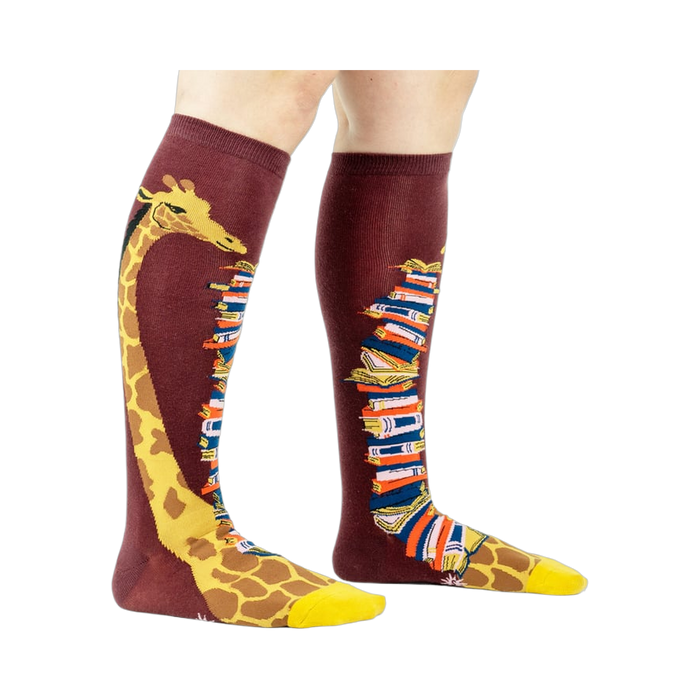 Knee-high socks on a model's legs, showcasing the giraffe and book design.