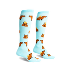 Pair of light blue knee-high socks with repeating pattern of brown capybaras and yellow ducklings.