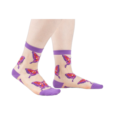 Sheer ankle socks in nude with purple cuffs and colorful butterfly designs. 