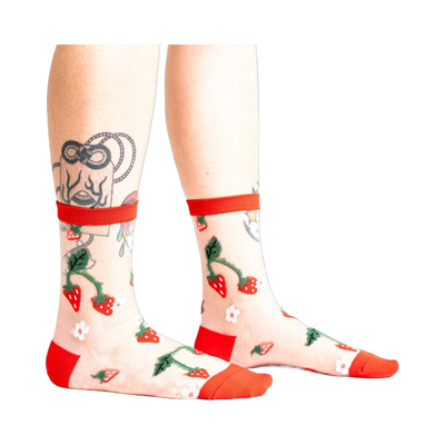 Pair of women's sheer ankle socks with a strawberry and flower design.  Red accents on the cuffs and toes complement the sheer mesh material.