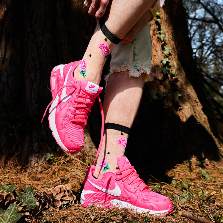 [lf] Pink rose-patterned sheer socks with black polka dots, worn with bright pink sneakers in a forest setting.