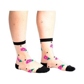 Sheer ankle socks with pink roses, green leaves, and black polka dots on a nude background. Black trim at the top.