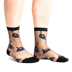 Front view of legs wearing sheer black ankle socks with dark blue and black rose patterns and small black dots on a white background.