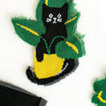 Detailed close-up showcasing the knitted design of a single black cat in a pot on the sheer sock fabric.