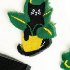 Detailed close-up showcasing the knitted design of a single black cat in a pot on the sheer sock fabric.