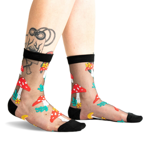 A pair of women's black sheer ankle socks adorned with red and white mushroom and flower designs. 