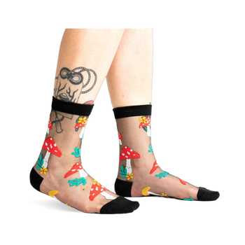 A pair of women's black sheer ankle socks adorned with red and white mushroom and flower designs. 