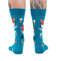 Back view of teal socks with shark and food design on a person's legs. 