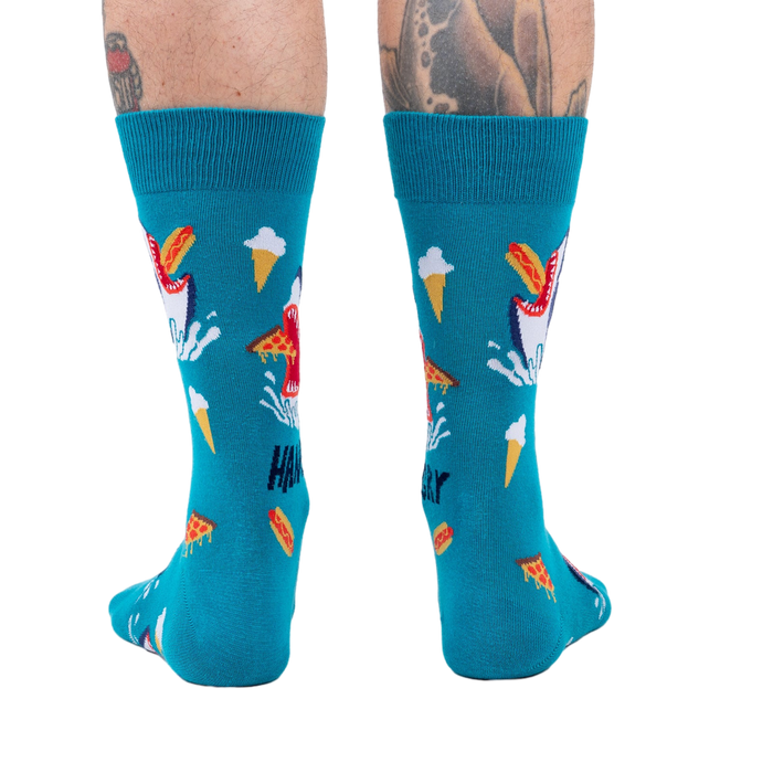 Back view of teal socks with shark and food design on a person's legs. 