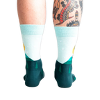Back view of the Star Buck socks on a person's legs, highlighting the design's continuation around the heel and ankle.