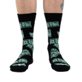 Flatlay image showcasing the black crew socks with green $100 bill design, highlighting the overall pattern.