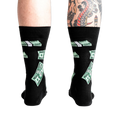 Rear view of the black crew socks with green $100 bill pattern on a model's legs.