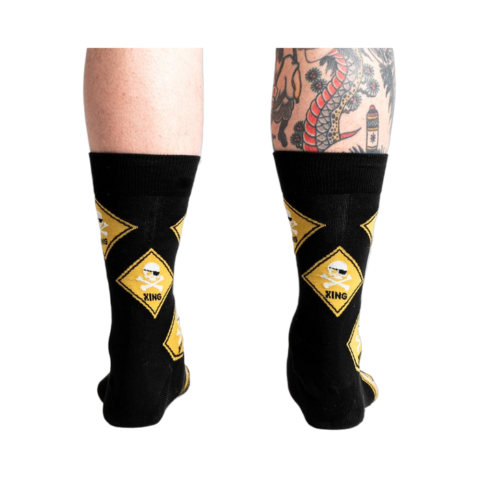 Rear view of 'Pirate Crossing' socks worn on a model's legs showing how the socks fit.