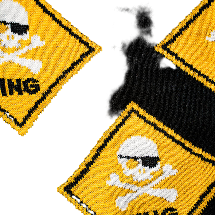 Close-up detail of the 'Pirate Crossing' sock's fabric, highlighting the skull and crossbones design and the knit texture.